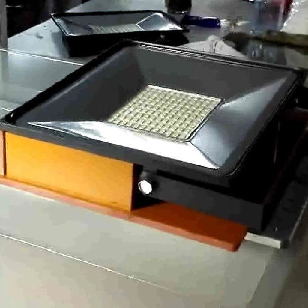 silicone application on LED flood light assembly